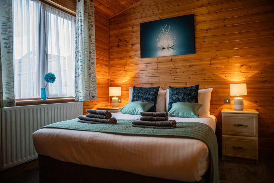 Warmly lit oak cabin bedroom. In the January Sale